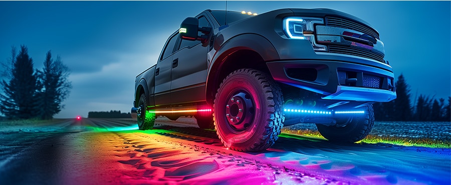 A truck with rainbow LED underglow illuminating misty road at night, highlighting off-road design and lighting features.